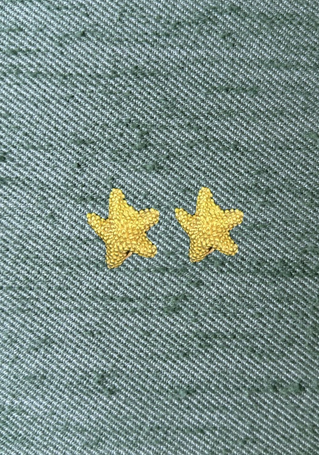 Tiffany & Co star-shaped textured gold earrings on green silk