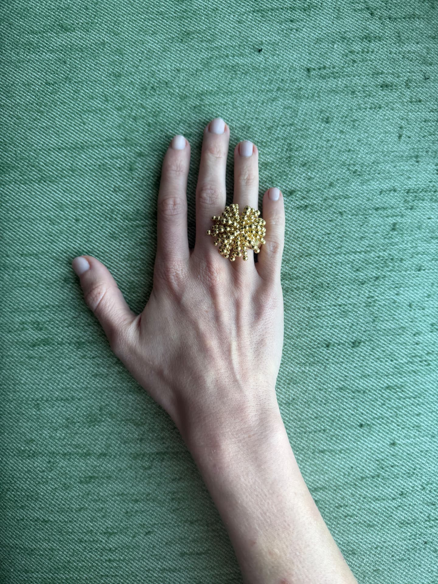 Vintage gold beaded cluster ring worn on a hand