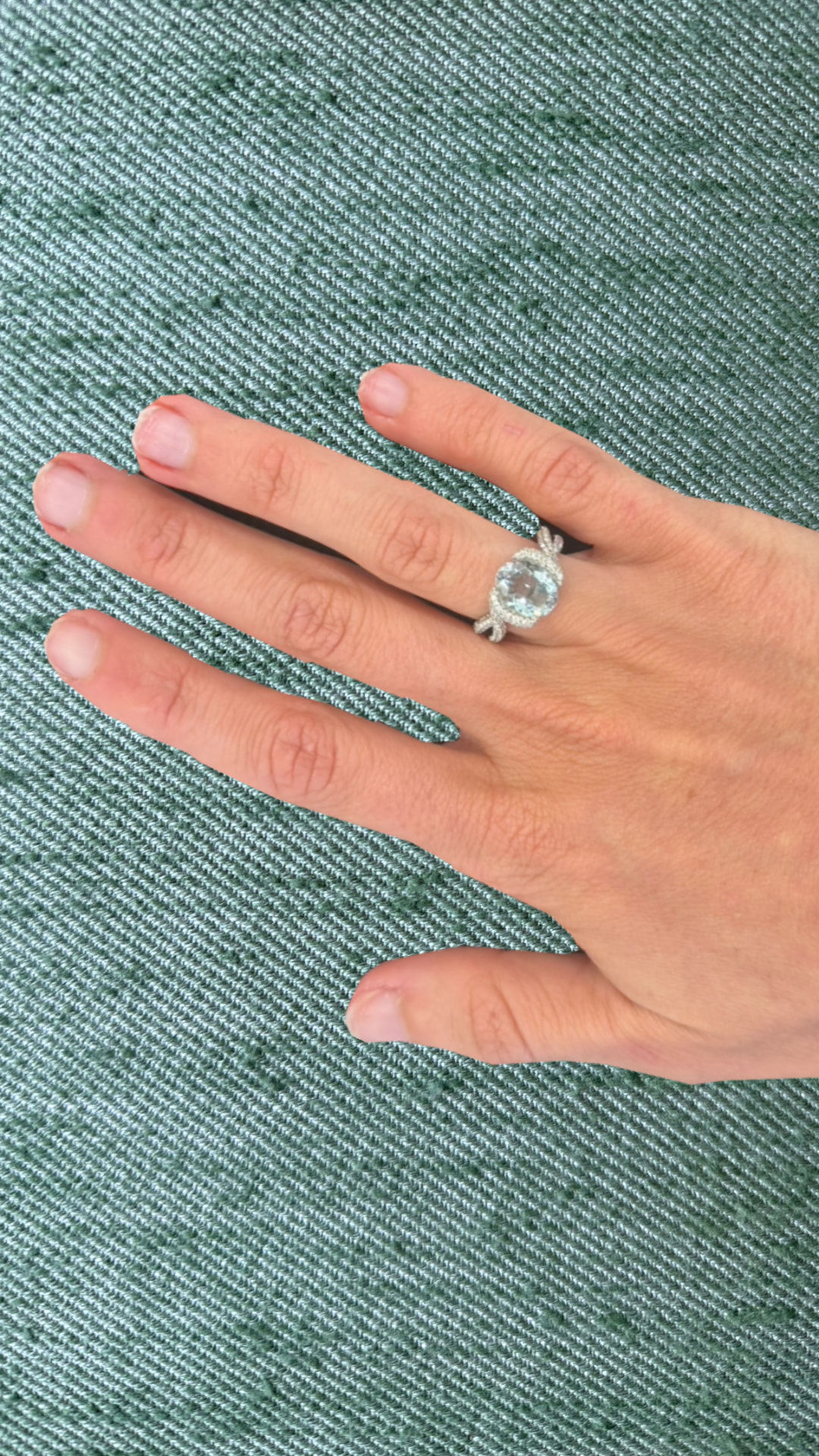 Aquamarine and diamond twist ring worn on a hand