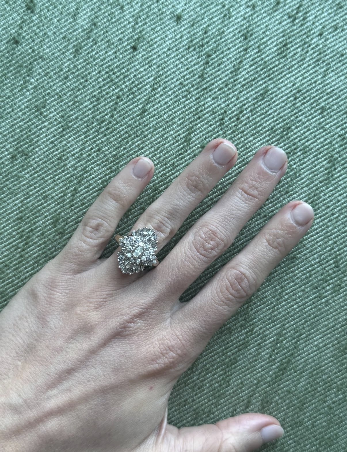 Diamond marquise and baguette cluster cocktail ring worn on a hand